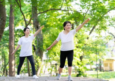 Parktaki Asyalı anne ve kız egzersizi