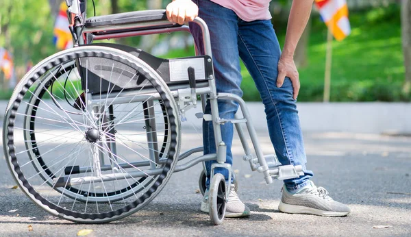 Tekerlekli sandalyede oturan orta yaşlı Asyalı kadın.