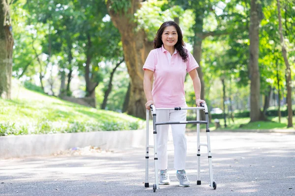 Orta yaşlı Asyalı bir kadının parkta yürüme çalışması.