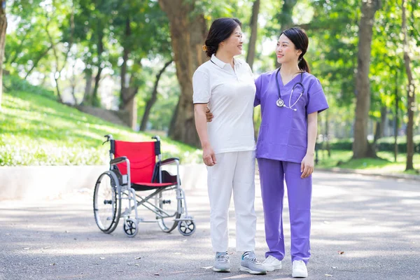 Азійська Медсестра Доглядає Пацієнткою Середнього Віку Парку — стокове фото