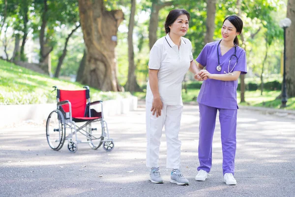 Азійська Медсестра Доглядає Пацієнткою Середнього Віку Парку — стокове фото