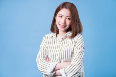 Mavi arka planda poz veren genç Asyalı kız