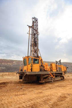Taş ocağında kuyu açmak için bir makine. Taş ocağına patlayıcı yerleştirmek için delikler açmak. Minerallerin açık çukur kazma teknolojisi.