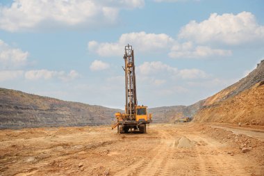 Taş ocağında kuyu açmak için bir makine. Taş ocağına patlayıcı yerleştirmek için delikler açmak. Minerallerin açık çukur kazma teknolojisi.