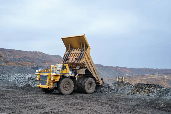 大きな黄色のダンプトラックはミネラルをアンロードします 鉱物の採掘と輸送のプロセス 露天掘り法による鉱石採掘 — ストック写真