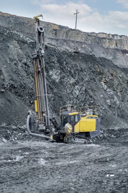 Sondaj makinesi sondaj için, taş ocağının doğru hatlarını oluşturuyor. Taş ocağına patlayıcı döşeme ve maden çıkarma teknolojisi için depoların hazırlanması.
