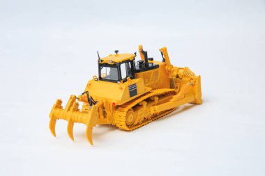Beyaz arka planda sarı buldozer. Büyük sarı bir buldozer modeli..