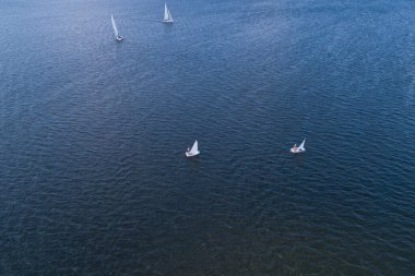 Güneşli bir günde, nehir yelkenli teknelerinde bozkır nehrinin havasından manzarayı seyret. Nehirde yelken sporları.