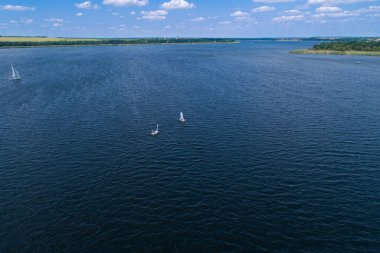 Güneşli bir günde, nehir yelkenli teknelerinde bozkır nehrinin havasından manzarayı seyret. Nehirde yelken sporları.
