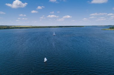 Güneşli bir günde, nehir yelkenli teknelerinde bozkır nehrinin havasından manzarayı seyret. Nehirde yelken sporları.