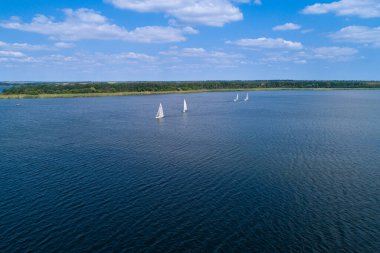 Güneşli bir günde, nehir yelkenli teknelerinde bozkır nehrinin havasından manzarayı seyret. Nehirde yelken sporları.
