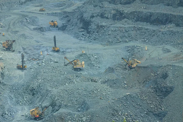 The process of iron ore mining in an open pit. Operation of drilling rigs in a quarry for the extraction of minerals. The initial stage of metallurgy.