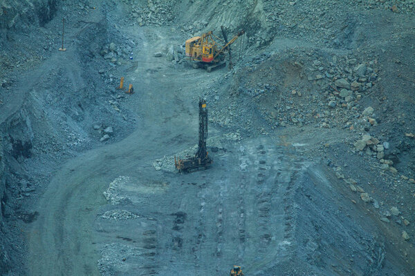 The process of iron ore mining in an open pit. Operation of drilling rigs in a quarry for the extraction of minerals. The initial stage of metallurgy.