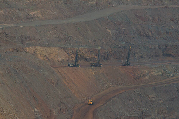 The process of iron ore mining in an open pit. Operation of drilling rigs in a quarry for the extraction of minerals. The initial stage of metallurgy.