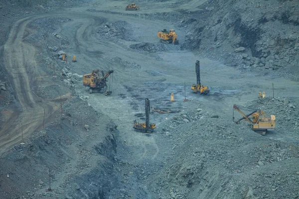 The process of iron ore mining in an open pit. Operation of drilling rigs in a quarry for the extraction of minerals. The initial stage of metallurgy.