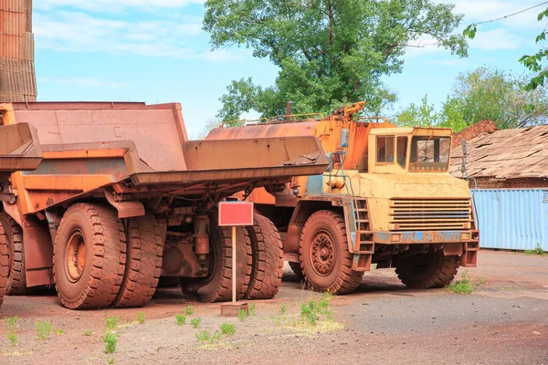 Decommissioned quarry trucks awaiting disposal. Iron ore mining equipment at the end of its useful life.