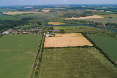Kırsal bölge güneşli bir günde, tarlalar ve köyler. Steppe ovasında nehir var. Kuş bakışı. Bir İHA görüntüsü.