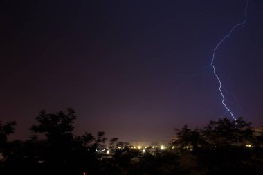 Şehrin üzerinde şimşekler çakıyor. Geceleyin bir yaz fırtınası.
