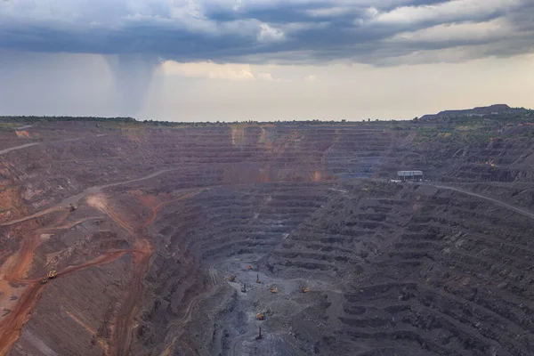 露天掘り鉄鉱石採掘 プロセス中にリグや掘削機をドリル 重鋼産業の初期生産チェーン 採石場の上に雷雨の雲 — ストック写真