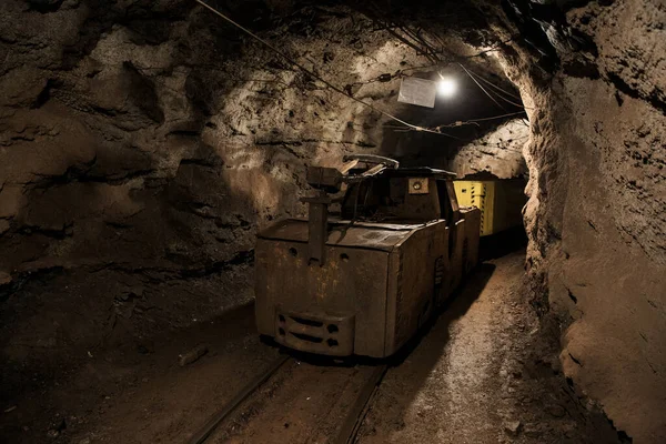 Dirty electric locomotive in the mine underground. Technologies of underground mining. Industrial equipment in the mine.