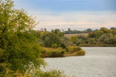 Landscape of a river or lake in the fall .Berga river with autumn colorful trees. Steppe autumn landscape.