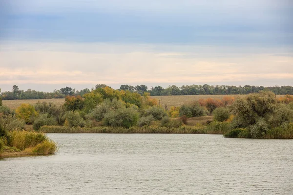 Landscape of a river or lake in the fall .Berga river with autumn colorful trees. Steppe autumn landscape.
