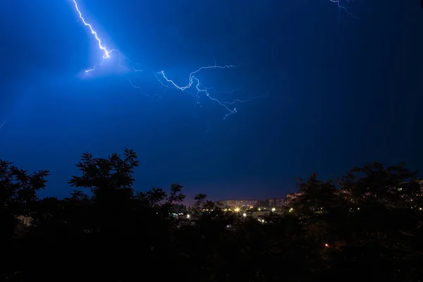 Lightning strikes on the outskirts of the city, thunderstorms in the woods near the city. Nighttime summer thunderstorm