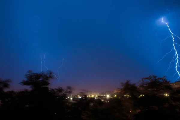 Lightning strikes on the outskirts of the city, thunderstorms in the woods near the city. Nighttime summer thunderstorm