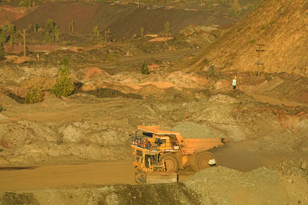 大規模なオープンピットダンプトラックは 採石場から地球の表面に鉄鉱石を運びます 露天掘り技術 採石場の上部の地平線のビュー 採掘技術 — ストック写真