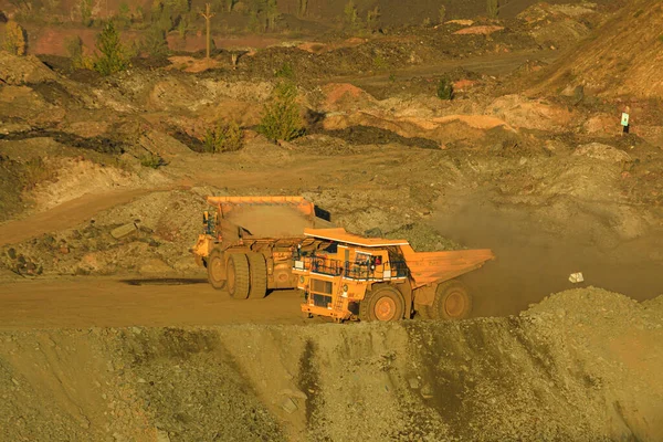 A large open-pit dump truck carries iron ore from the quarry to the surface of the earth. Open pit mining technologies. View of the upper horizons of the quarry. Technique for mining.