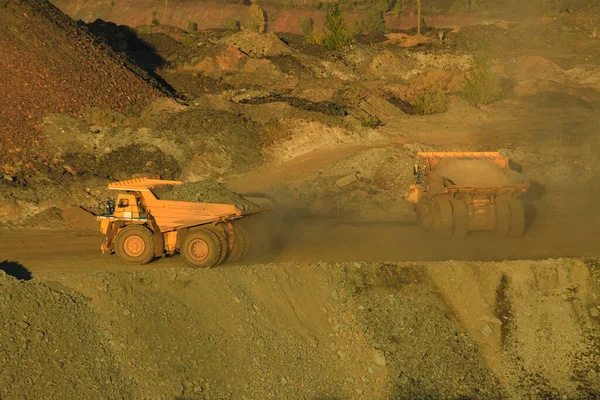 A large open-pit dump truck carries iron ore from the quarry to the surface of the earth. Open pit mining technologies. View of the upper horizons of the quarry. Technique for mining.