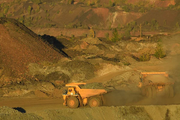 A large open-pit dump truck carries iron ore from the quarry to the surface of the earth. Open pit mining technologies. View of the upper horizons of the quarry. Technique for mining.