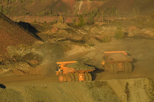 The process of unloading a large dump truck that carries minerals. The technology of ore mining, raw materials for metallurgy.