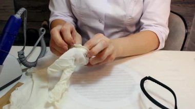 Profesyonel manikürcü beyaz tıbbi eldiven giyer. Manikür güzellik salonunda müşteri hizmetlerine hazırlanılıyor.
