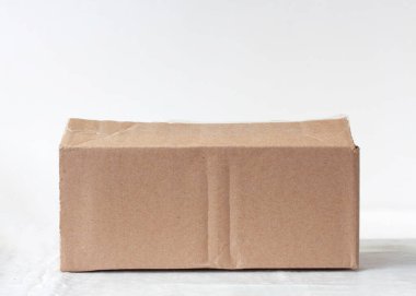 Beyaz arka planda buruşmuş küçük bir karton kutu.