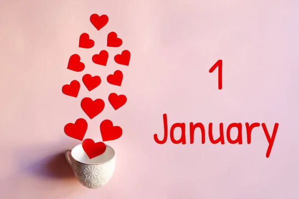 红心从白色的杯子里掉了出来 红字1月1日粉红底色 新年概念 — 图库照片