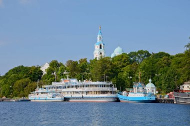 Valaam adası, ormanın yeşilliğinde açık bir günde. Dönüşüm Valaam Katedrali 'nin çan kulesi ve küçük gemilerin iskelesi.