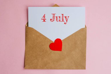 Üzerinde beyaz bir kağıt ve kırmızı kalpli 4 Temmuz tarihli Kraft zarfı. Pembe arka plan, romantizm ve aşk konsepti üzerine düz uzandı