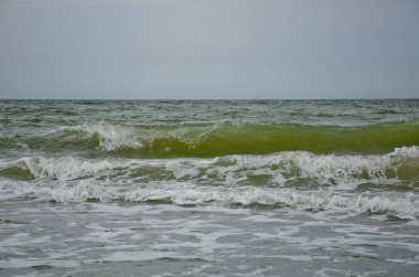 Deniz kıyısında dönen küçük dalgalar, yaz bulutlu bir gün, tatil konsepti