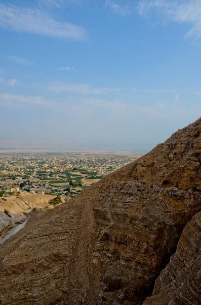 Günah dağlarından Jericho şehrinin manzarası. Dağların eteklerindeki antik ve sıcak şehir, dikey fotoğraf.