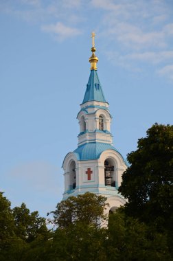 Şekil Değiştirme Katedrali 'nin çan kulesi açık mavi gökyüzünün arka planında. Valaam Ortodoks Dönüşüm Manastırı Bir yaz günü ağaçların yeşilinde, dikey fotoğraf.