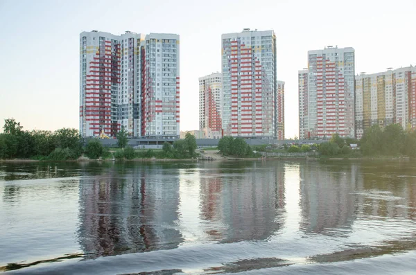 St. Petersburg 'daki Neva Nehri' nin kıyısında yeni binalar. Güneşli yaz gününde sudan manzara.