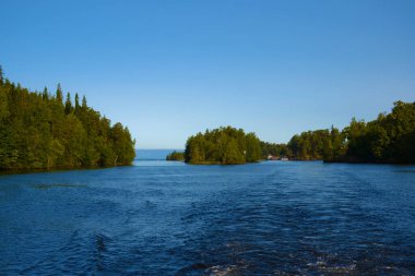 Göldeki adalarda yoğun, vahşi, yeşil bir orman. Açık bir günde, mavi gökyüzünde bir gemiden gelen su dalgaları. Tatil kavramı