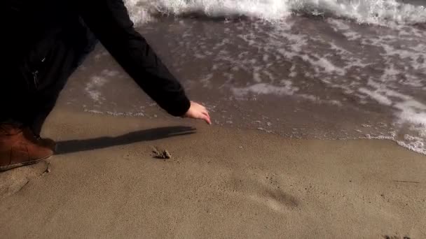 手の砂の上に心を描画して波オフに洗浄 — ストック動画