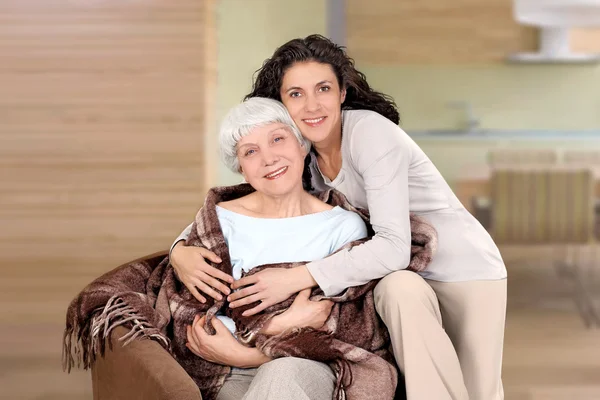 yaşlı kadın ve battaniye ile bir sandalyede oturan kızı