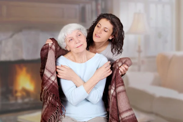 Daughter carefully conceals mom blanket in the room with a firep — Stock Photo, Image