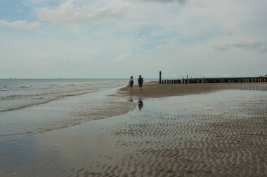 Deniz kıyısında yürüyorum.