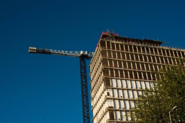 İnşaat alanında mavi gökyüzü arka plan üzerinde Vinçli