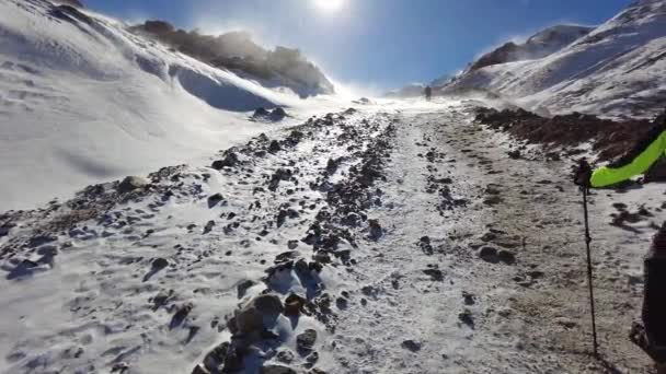 Turista sobe alto para as montanhas durante uma tempestade de neve — Vídeo de Stock