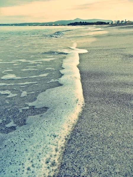 Schuimende zee op het strand — Stockfoto